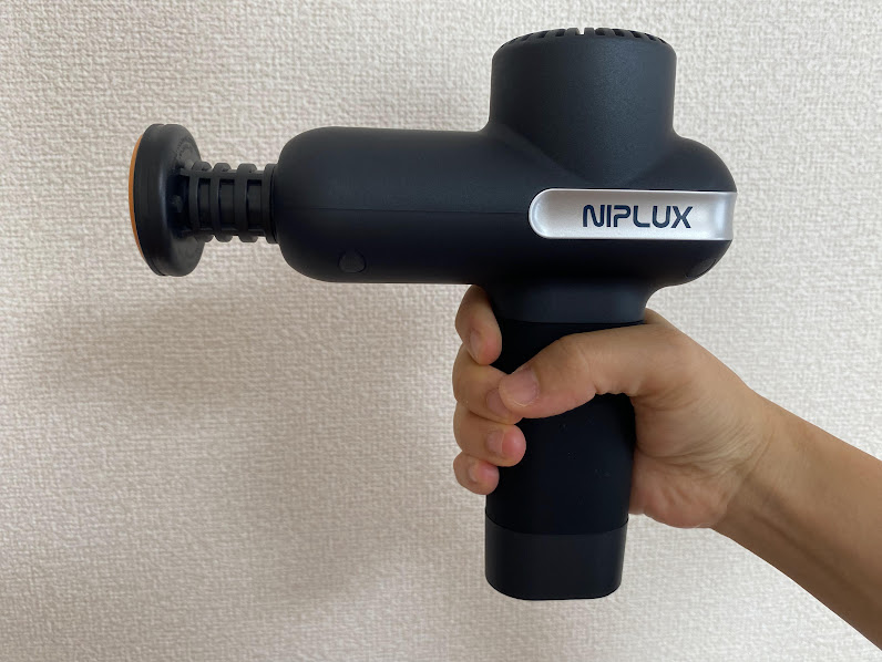 「NIPLUX」マッサージガンを持った様子